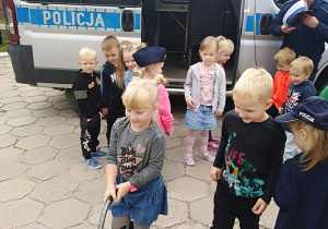 Dzieci w ogrodzie przedszkolnym oglądają sprzęt potrzebny do pracy w policji