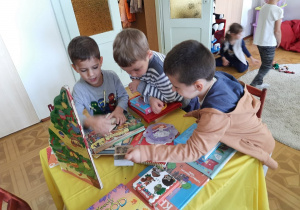 Dzieci oglądają książki w kąciku czytelniczym