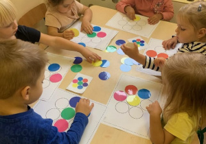 Dzieci z kolorowych kół wyciętych z papieru tworzą kwiatka