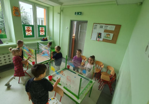 Dzieci malują na streczu kolorowe przedszkole