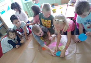 Dzieci współpracują przy tworzeniu grupowej pracy