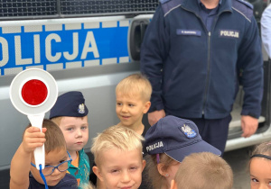 Chłopiec pokazuje dzieciom "lizak" policyjny