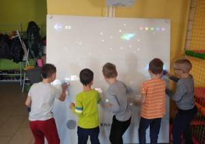 Chłopcy grają na tablicy interaktywnej