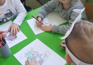 Dzieci kolorują rysunki piesków