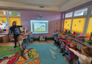 Grupa dzieci wskazuje na tablicę multimedialną