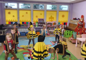 Dzieci przebrane za pszczółkę, księcia tańczą na środku sali