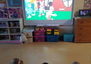 Dzieci oglądają na tablicy multimedialnej bajkę "W klubie Myszki Miki"