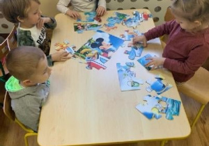 Dzieci układają puzzle z wizerunkiem Myszki Miki