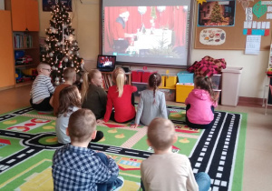dzieci oglądają film edukacyjny o tradycjach związanych ze Świętami Bożego Narodzenia