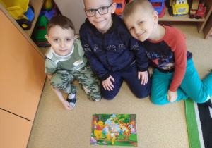 Trzech chłopców ułożyło puzzle z Kubusiem Puchatkiem