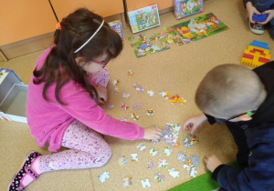 Dzieci układają puzzle z Kubusiem Puchatkiem