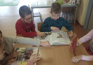 Dzieci oglądają książki o dinozaurach