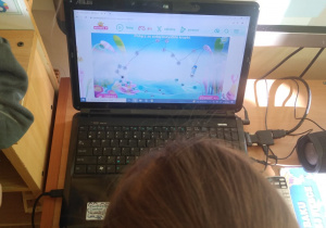 Dziecko łączy po kolei cyfry na komputerze