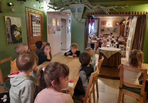 Dzieci jedzą ciastko z wiśnią przy stoliku