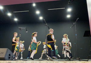 Dzieci tańczą krakowiaka na scenie