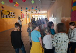 Przedszkolaki w towarzystwie uczniów zwiedzają budynek szkoły