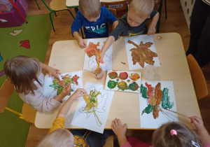 Dzieci malują farbami szablon liścia klonu