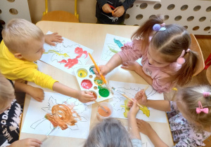 Dzieci malują farbami szablony jesiennych liści