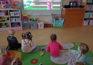 Dzieci oglądają bajkę "Masza i niedźwiedź" na tablicy multimedialnej
