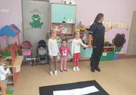 Pani Policjantka uczy trzy dziewczynki jak prawidłowo przechodzić przez pasy