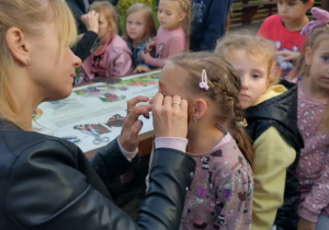 Nauczycielka maluje twarze dzieciom