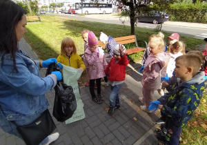 dzieci słuchają zasad bezpiecznego zbierania śmieci