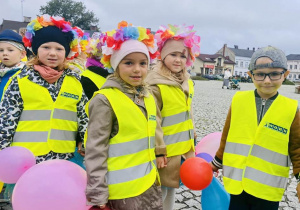 dzieci w kolorowych strojach, z balonami, stoją parami, autor UM Ozorków