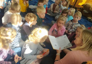 dzieci słuchają opowiadania czytanego przez panią bibliotekarkę