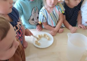 Dziewczynka kroi banana na małe kawałki.