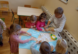 Dzieci wydzierają kawałki białej bibuły