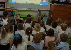 Dzieci oglądają film edukacyjny o Polsce na tablicy multimedialnej