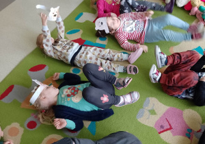 Dzieci leżą na dywanie - zabawa grupowa