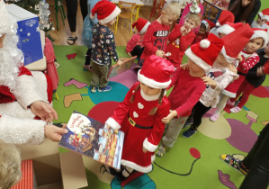 Mikołaj wręcza książkę dziewczynce