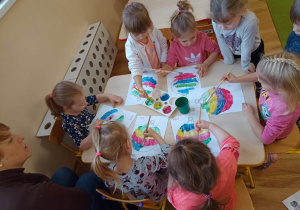 Dzieci malują farbami bombkę