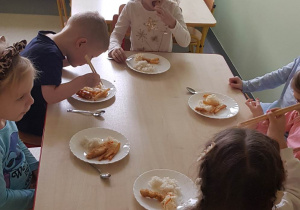 dzieci siedzą przy stoliku, dzieci próbują, smakują chińskie przysmaki