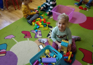 Dziewczynka konstruuje budowle z LEGO DUPLO
