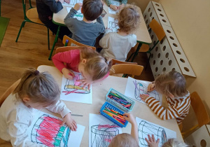 Dzieci wypełniają kredkami kontury obrazka przedstawiającego bębenek
