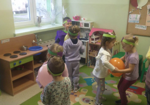dzieci tańczą na dywanie z balonem