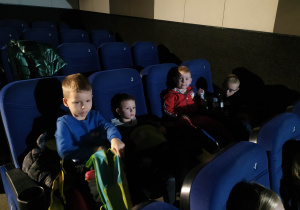 chłopcy zajmują miejsca na sali kinowej