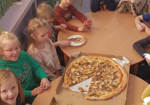 dzieci jedzą pizze