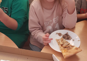 dziewczynka spożywa pizze
