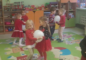 dzieci tańczą na dywanie z balonami w rytm - Serduszko Puka W Rytmie cza cza