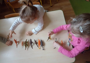 Dzieci bawią się figurkami dinozaurów