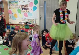 Dziewczynki biorą udział w konkurencji "Taniec na kolorowym papierze"
