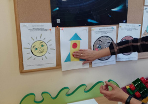 Nauczycielka objaśnia jak wykonać rakietę kosmiczną z figur geometrycznych