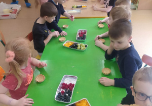 dzieci tworzą desery z owocami