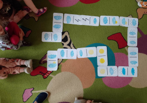 Domino z symbolami pogodowymi ułożone przez dzieci