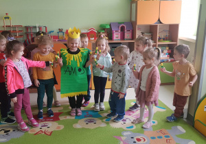 dzieci pozują do zdjęcia wraz z dziewczynka w stroju- klej AMOS, dzieci trzymają w rączkach kleje AMOS