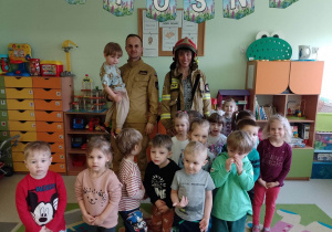 Dzieci z grupy Pszczółek wraz z wychowawczynią pozują do zdjęcia z panem strażakiem