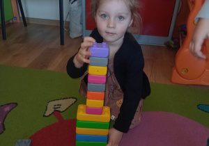 Dziewczynka prezentuje jeden z zabytków Włoch - Krzywą Wieżę w Pizie zbudowaną z klocków